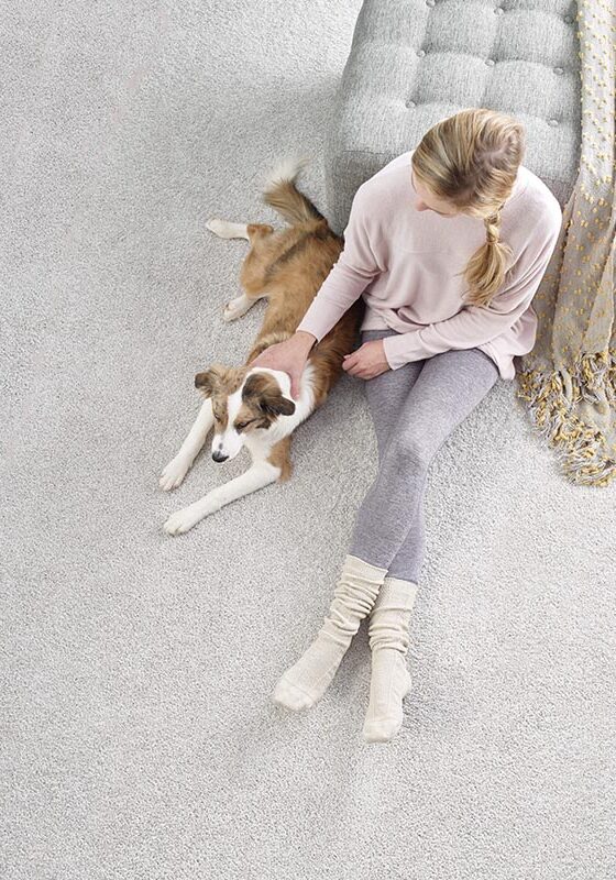 Lady with dog sitting on carpet | Kelly's Carpet Omaha